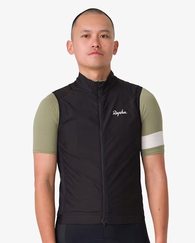 Rapha Core Cycling Gilet worn by a model, front view with black gilet zipped over a green Rapha cycling jersey