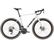 A Trek endurance road bicycle with a white frame featuring a subtle light blue and gray speckled pattern, black handlebars, black wheels, and tan sidewall tires, shown against a plain white background.