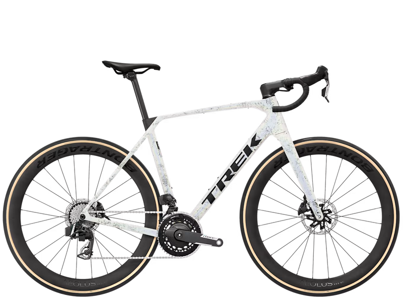 A Trek endurance road bicycle with a white frame featuring a subtle light blue and gray speckled pattern, black handlebars, black wheels, and tan sidewall tires, shown against a plain white background.