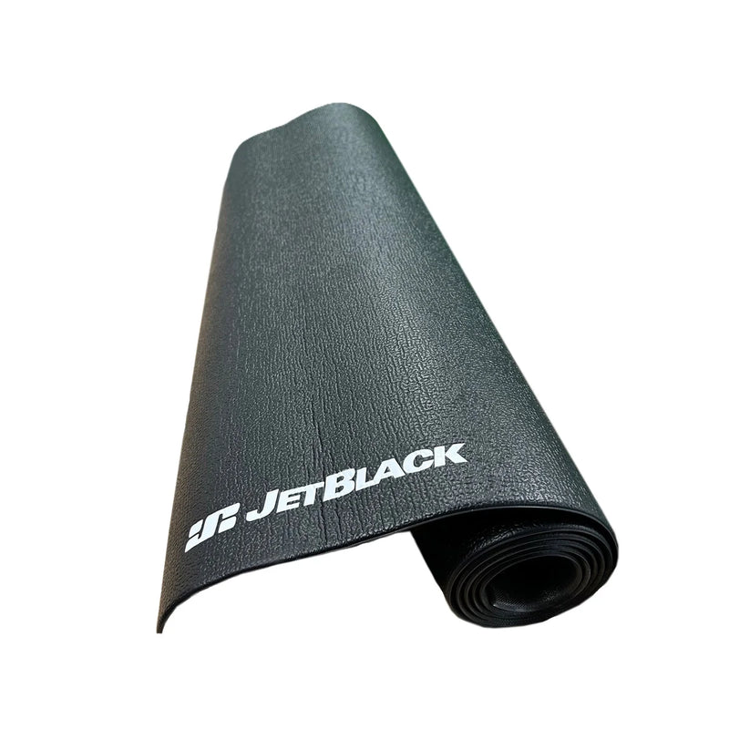 JetBlack Cycling trainer mat partially rolled on white background with the white JetBlack logo visible and textured black surface showing.