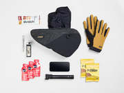 Flat lay of the Trek Adventure Triangle Bag 1.6L with a variety of cycling gear that fits inside the pouch.
