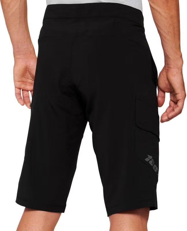 Rear product view of black 100% Ridecamp mountain bike shorts featuring back waistband stitching, prominent 100% logo branding, and side cargo pocket