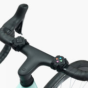 Closeup of Zwift Click V2 controllers mounted on bike handlebars