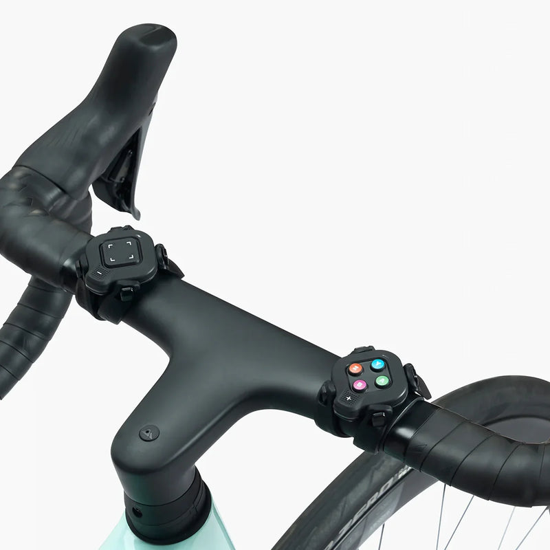 Closeup of Zwift Click V2 controllers mounted on bike handlebars