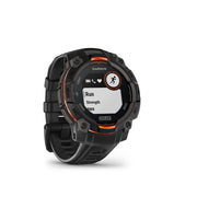 A Garmin Solar watch with a rugged black case and strap, featuring orange accents around the bezel and screen border, shown on a clean white background.