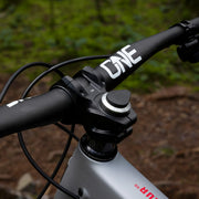 Close-up of a bicycle handlebar with 'ONE' branding against a natural background