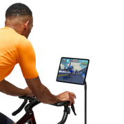 Rider using Zwift Click V2 while cycling indoors with a screen in front