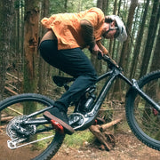 Person riding a mountain bike through a forest