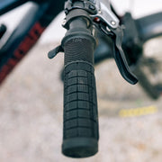 Close-up of a bicycle handlebar with textured grip and brake lever.