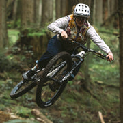 Person riding a mountain bike through a forest