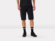 Person wearing mountain bike black shorts and black shoes with gray stripes on a white background