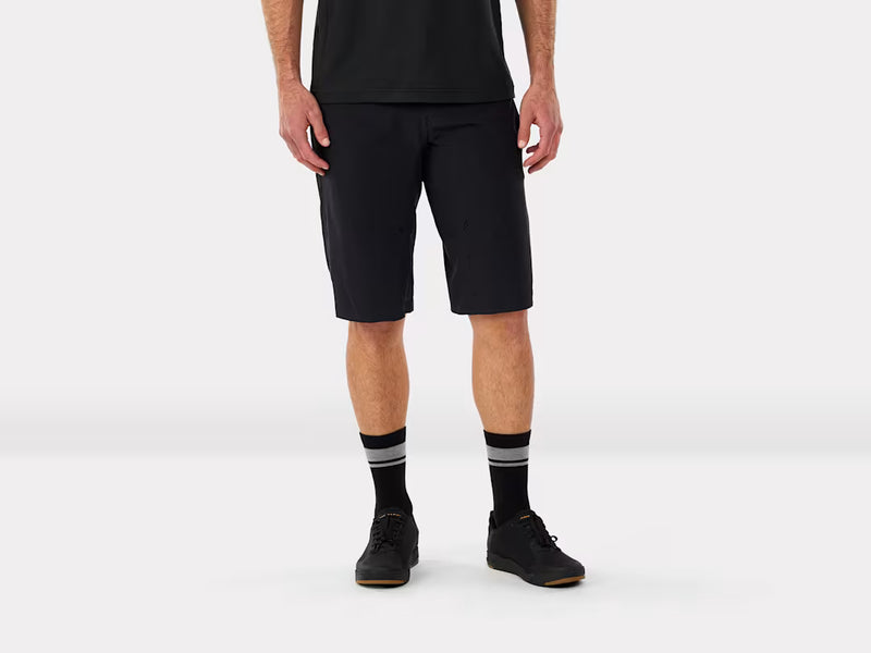 Person wearing mountain bike black shorts and black shoes with gray stripes on a white background
