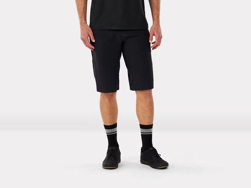 Person wearing mountain bike black shorts and black shoes with gray stripes on a white background