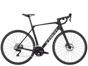 A black Trek road bicycle with drop handlebars, disc brakes, and a carbon fiber frame, shown from a side profile on a solid white background.