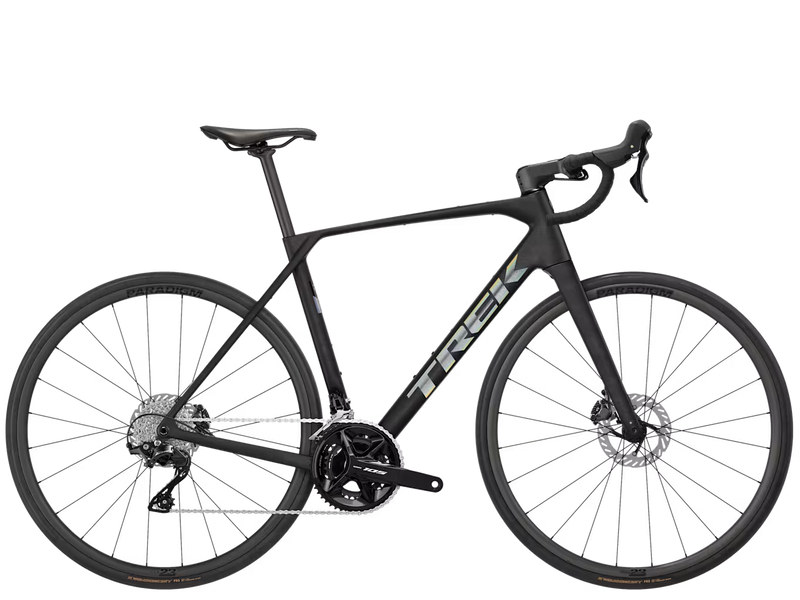 A black Trek road bicycle with drop handlebars, disc brakes, and a carbon fiber frame, shown from a side profile on a solid white background.