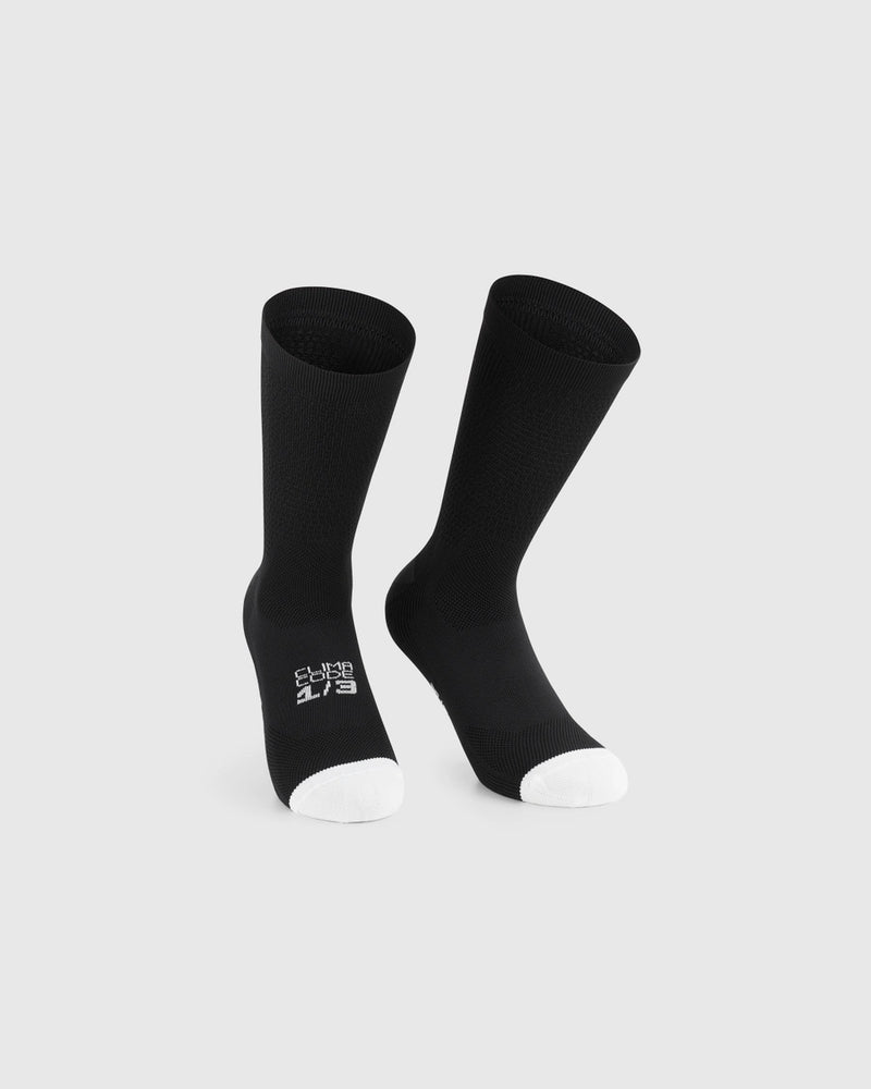 Two black socks with white accents on a light gray background