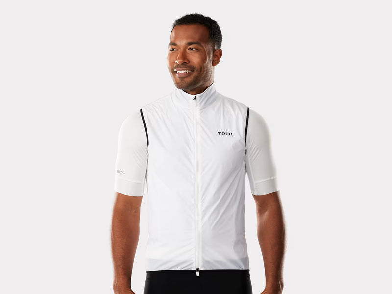 Man wearing a white cycling jacket with 'Trek' branding on a white background