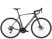 A matte dark purple Trek road bicycle with black components, drop handlebars, and disc brakes, shown from a side profile on a solid white background.