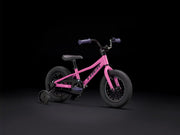 Pink balance bike with training wheels on a black background