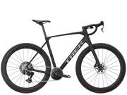 A black Trek endurance road bicycle with drop handlebars, deep carbon fiber wheels, and a central chain guard, shown from a side profile on a solid white background.