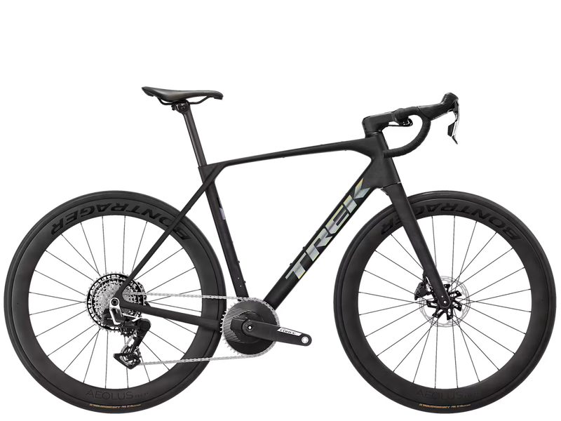 A black Trek endurance road bicycle with drop handlebars, deep carbon fiber wheels, and a central chain guard, shown from a side profile on a solid white background.