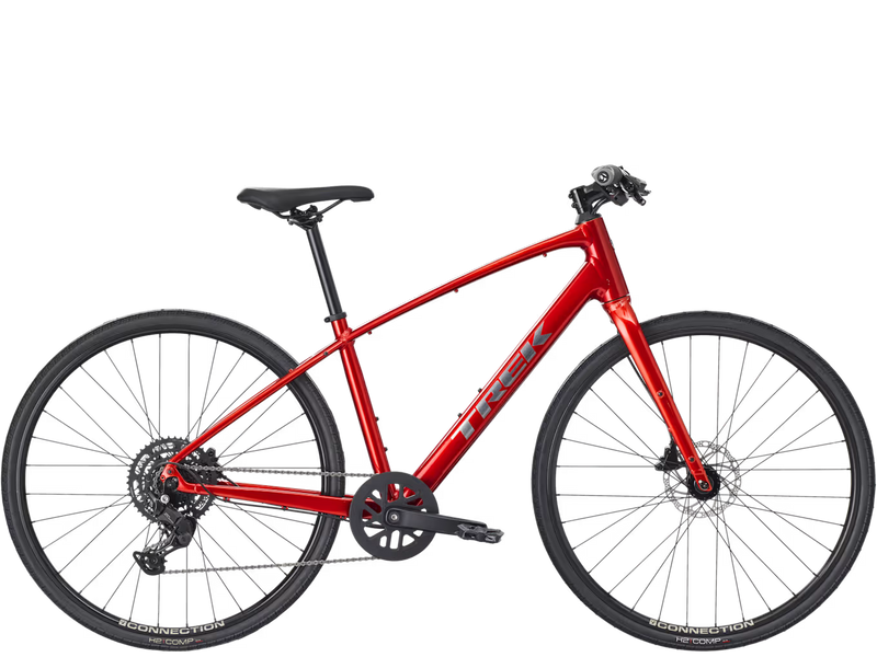 A red Trek hybrid fitness bicycle with black components, tires, and saddle, shown from a side profile view against a solid white background.