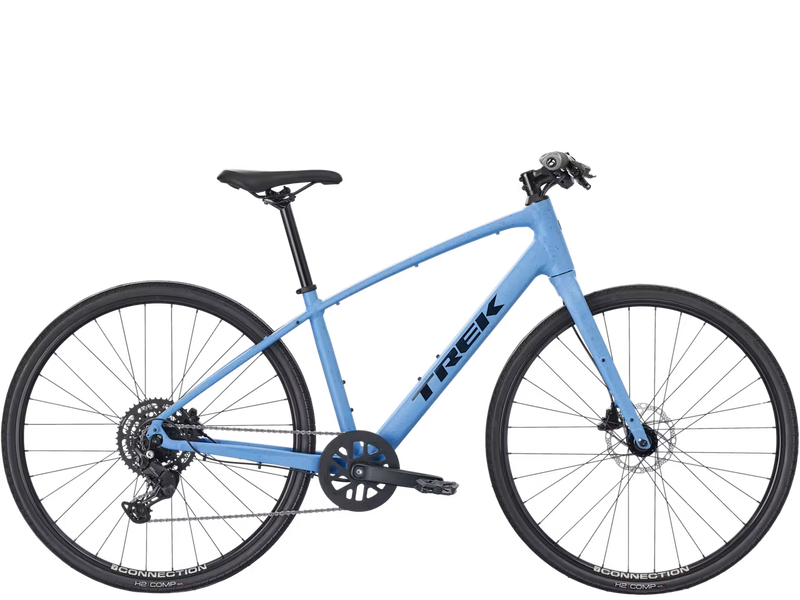 A light blue hybrid fitness Trek bicycle with black components, black tires, and a black saddle, shown from a side profile on a solid white background.