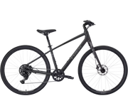 A matte black stepover cruiser Trek bicycle with a step-through frame, front suspension fork, disc brakes, and rear derailleur, shown from a side profile on a white background.