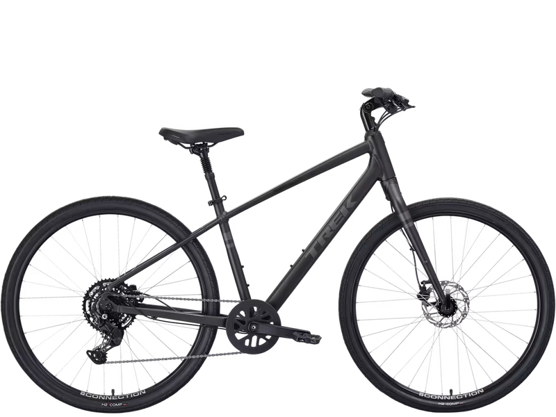 A matte black stepover cruiser Trek bicycle with a step-through frame, front suspension fork, disc brakes, and rear derailleur, shown from a side profile on a white background.