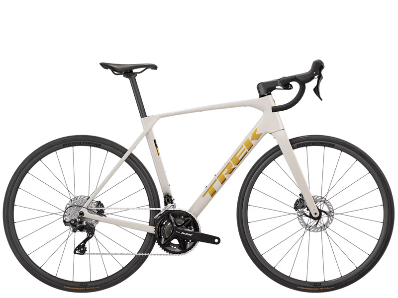 A white Trek road bicycle with black components and gold logo detailing, shown from a side profile view against a solid white background.