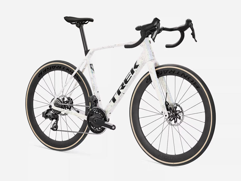 A white Trek endurance road bicycle with black components, drop handlebars, and dark wheels with beige sidewalls, photographed on a clean light gray studio background.