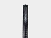 Black tire with tread pattern on a light gray background