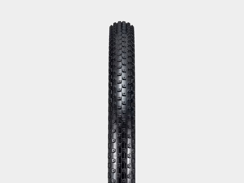 Black tire with tread pattern on a light gray background