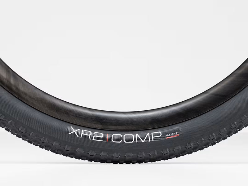 Close-up of a bicycle tire with 'XR2 COMP' branding on a white background