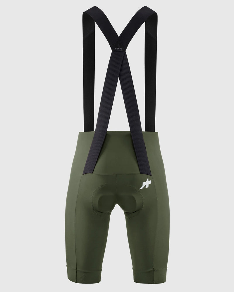 Green cycling bib shorts with black suspenders on a white background