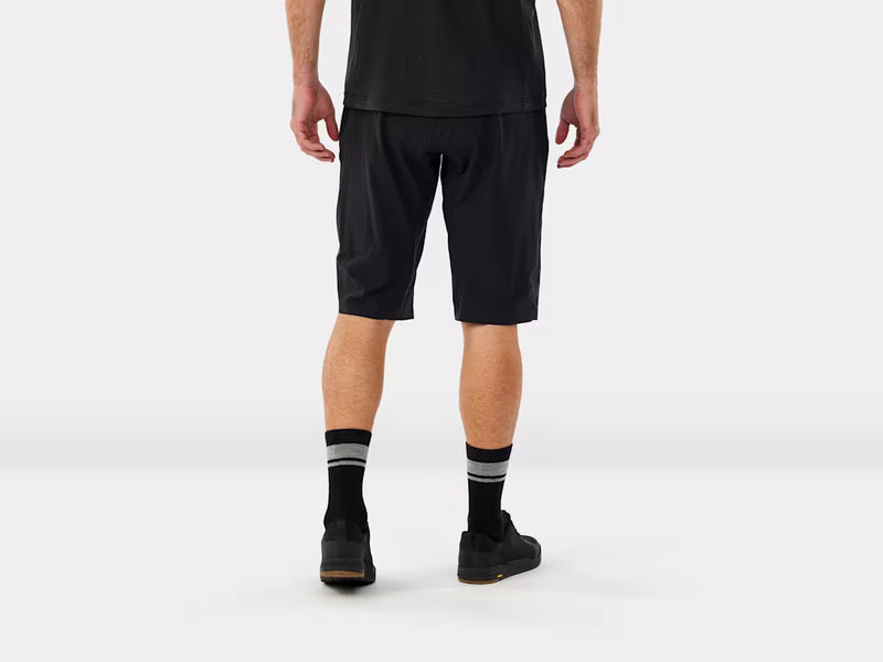 Person wearing mtb black shorts and socks on a white background, back view