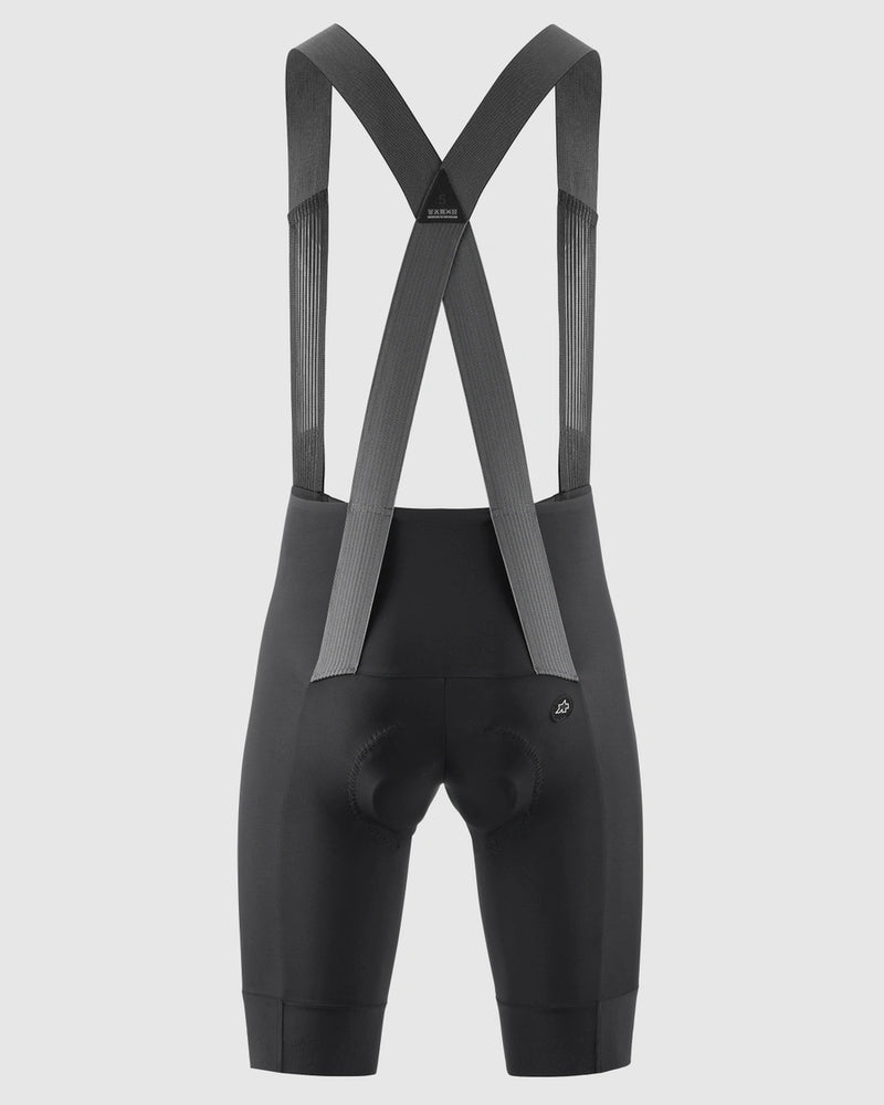 Black cycling bib shorts with suspenders on a light gray background