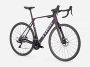 A Trek road bicycle in a dark purple frame with black components, drop handlebars, and thin tires, shown on a light gray studio background.