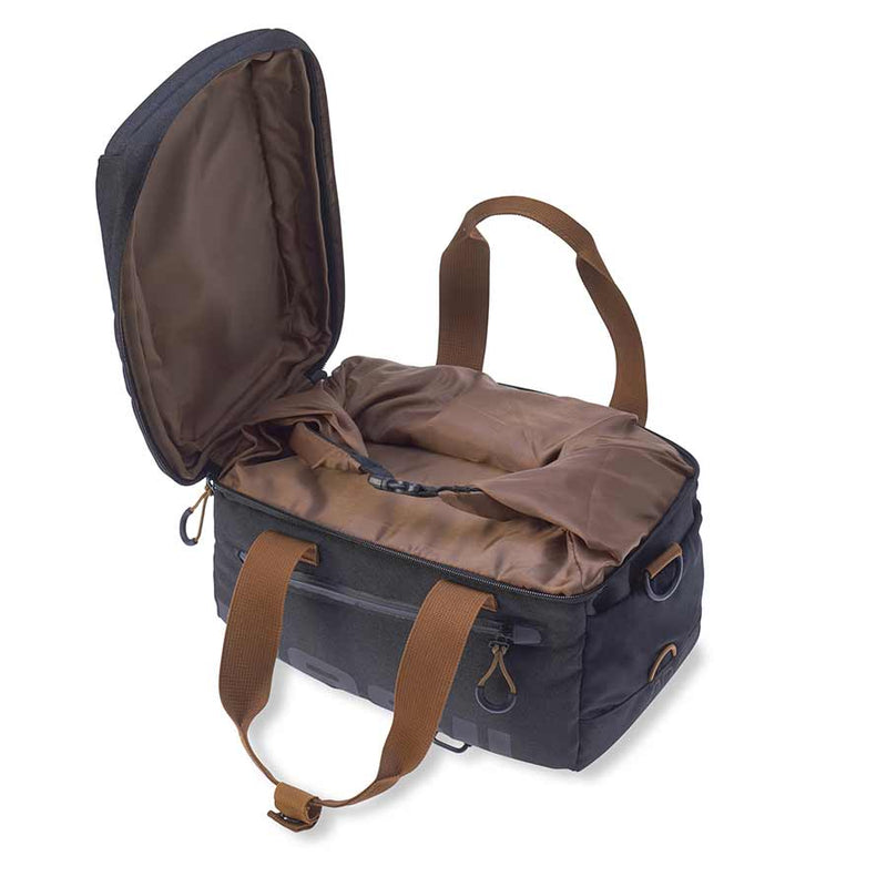 asil Miles Trunk Bag 7L in Black Slate, three-quarter view with the bag open, showing the brown interior and additional securing strap
