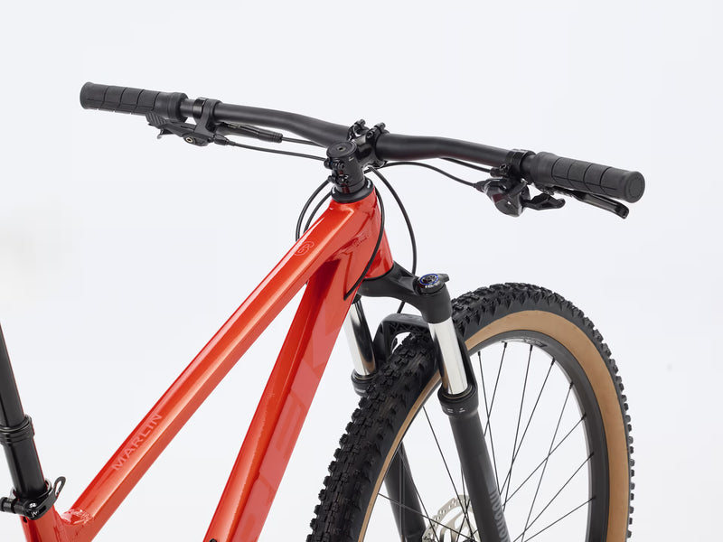 Red bicycle with a black seat and handlebars on a white background