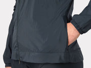 Dark gray jacket worn by a person on a light gray backgroundm close up of bottom, zipper, cuffs and pockets.