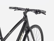 Black hybrid fitness bicycle with brand logo \Trek' and product name 'FX' visible, against a white background