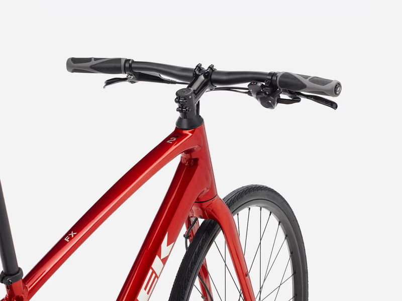 Red hybrid fitness bicycle with black handlebars on a white background, product name 'FX' and 'Trek' logo visible.