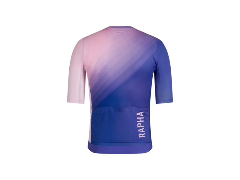 Rapha cycling jersey shown from the back, featuring a pink-to-blue gradient design with the brand name 'RAPHA' printed vertically in white on the lower back. Back pockets visible.