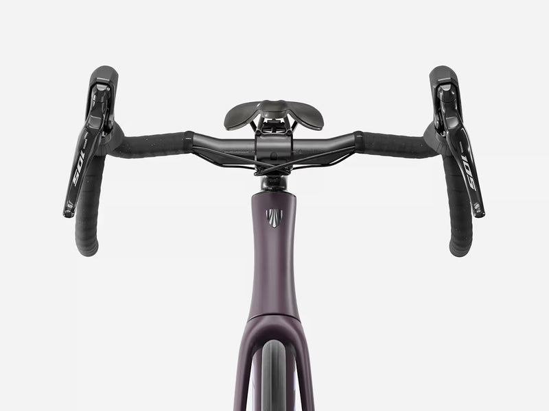 Front view of a road bicycle handlebar area showing a matte dark purple frame, black drop handlebars, black brake levers with Shimano branding, and a black saddle against a light gray background.