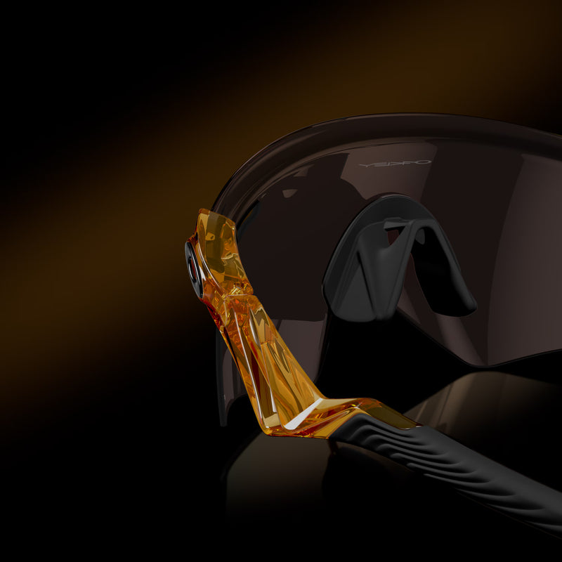 Helmet with a visor being applied by a gloved hand on a dark background