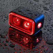Lifestyle close-up of the Magicshine Seemee 300 taillight illuminated in red on a bicycle in the rain