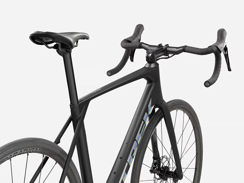 Trek Domane SL 4 Gen 5 in Matte Deep Smoke, rear three-quarter view showing Domane frame logo, Bontrager Paradigm wheels, handlebars, and Trek bar-end detail