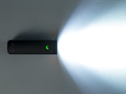 Black electronicbike light with a green light on a white background
