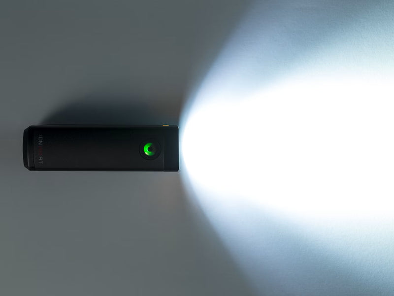 Black electronicbike light with a green light on a white background